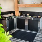 Rozsdamentes acél kültéri konyhaelem fekete ajtóval és munkalappal